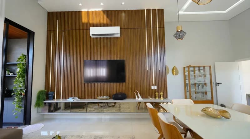 Home theater com painel ripado em Louro Freijó, base Branco Diamante, LED embutido e espelho bronze.