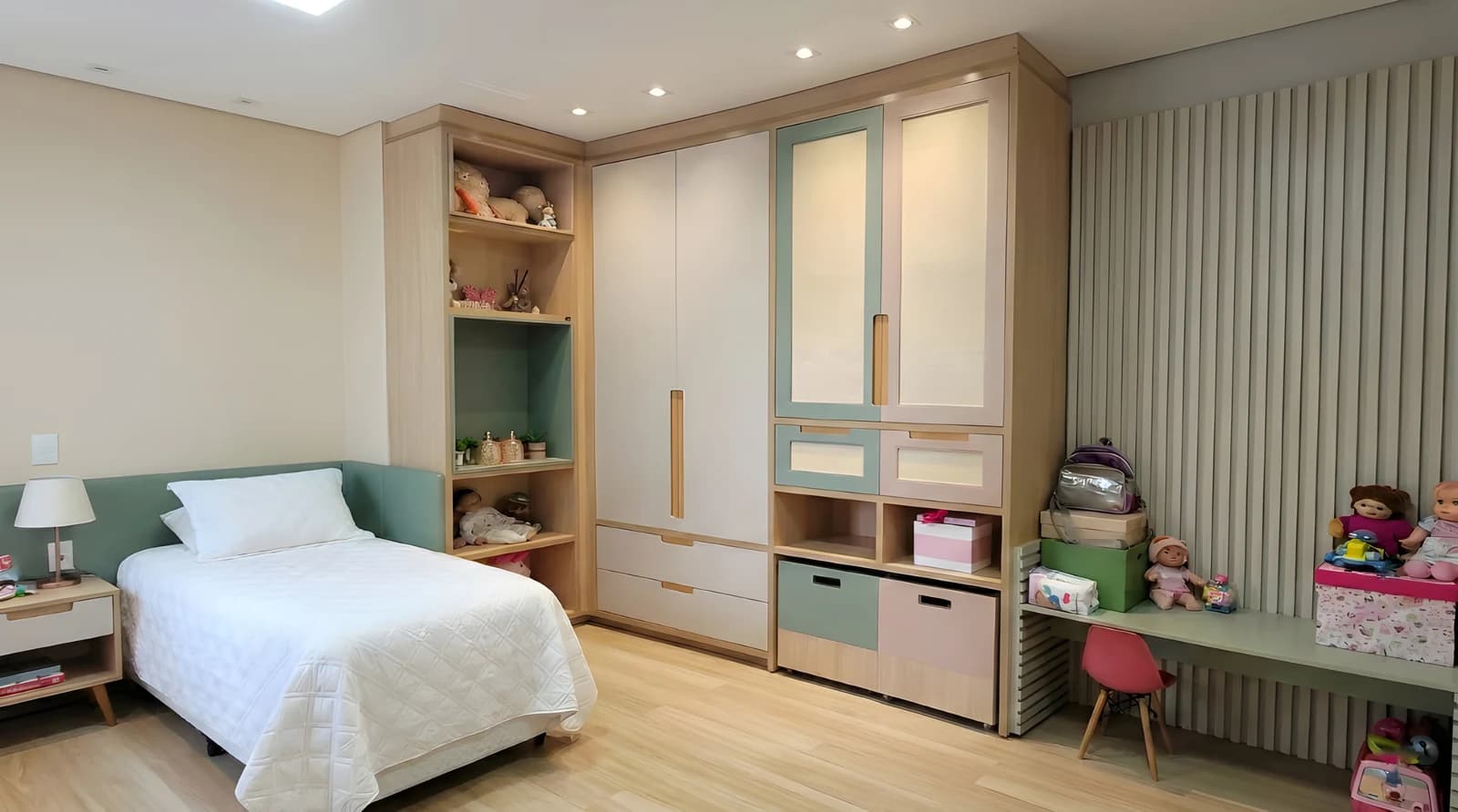 Quarto infantil planejado com armário em Verde Jade e Sal Rosa, madeira Carvalho Poró, painéis ripados e cama com cabeceira estofada.