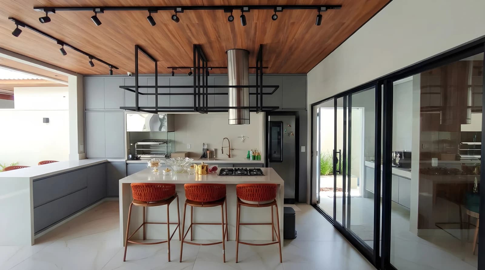 Varanda gourmet com ilha em pedra Bege Ártico, armários em MDF Gouthier Mesh e portas Roma com Alumínio Bronze.