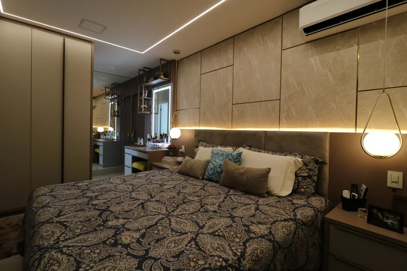 Cabeceira planejada em MDF Fontana magma e Rosato, com painel de frisos dourados e retroiluminação difusa.