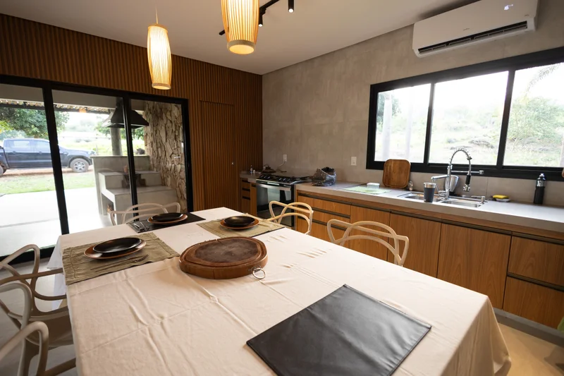 Cozinha de fazenda com MDF Louro Freijó, Portas Roma Bronze e bancada clara sob luz natural e pendentes