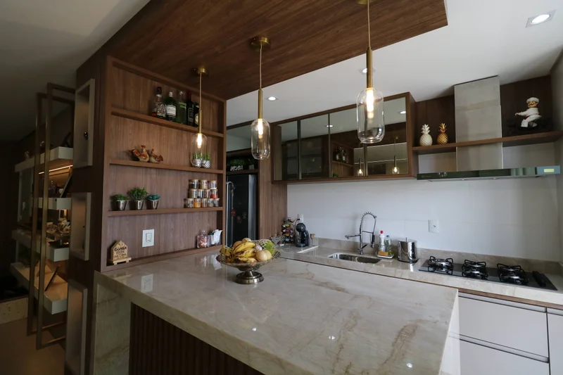 Cozinha planejada em Nogueira Pecan, com portas Florença Connect Chess e vidro Reflecta Bronze, pendentes e bancada clara.