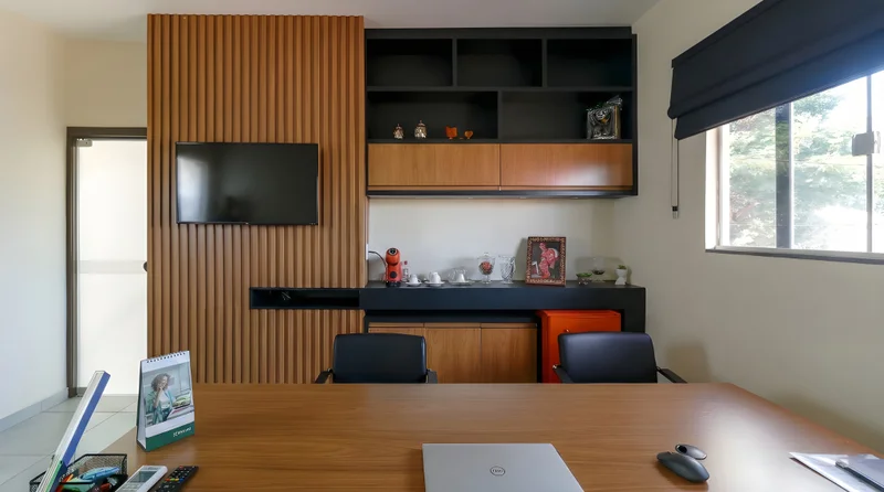 Escritório Master Chief com painel ripado Louro Freijó, marcenaria preta e portas com cava alumínio bronze.