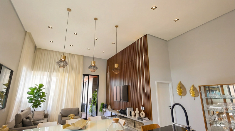 Home theater com painel ripado em Louro Freijó, base Branco Diamante, LED embutido e espelho bronze.